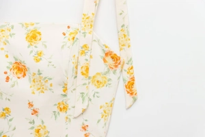 Detailaufnahme der Blumen-Träger und des Ausschnitts an diesem süßen cremefarbenen Kleid