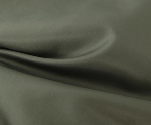 Detail shot of army green fabric with micro-mesh texture on a casual vintage jacket