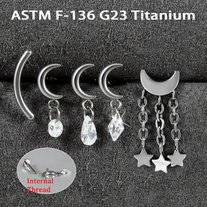 Detail showing G23 titanium labret studs with moon and heart charms and internal thread
