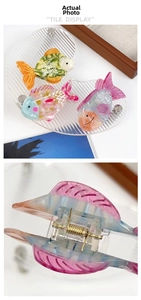 Macro detail of fish-shaped acetate hair claw clips showing the sturdy metal spring mechanism