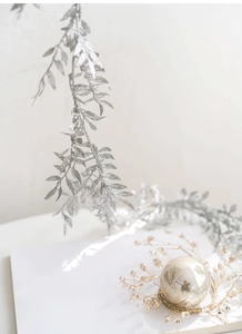 Close-up of glittery silver leaf garland with gold wire pearl and crystal bead ornament