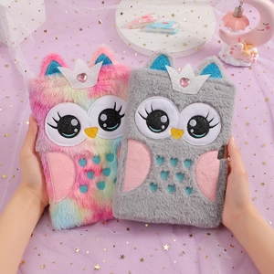 Detail of plush owl notebook cover with sequin crown and heart gem being held by hand
