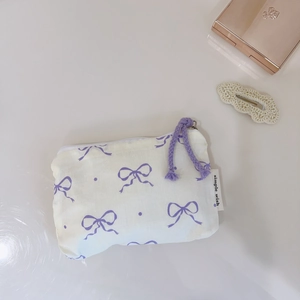 Detailed close-up of a floral cotton coin pouch with purple bow print and zipper