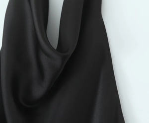 Detail des schwarzen Satin-Neckholder-Trägers mit seidiger Textur und glänzendem Finish