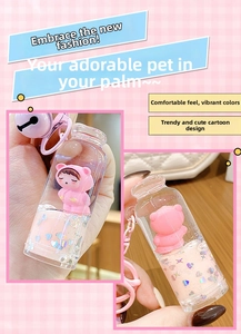 Close-up of pink liquid quicksand keychain with bear figurine and heart sequins