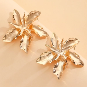 Detail of large 3D folded metallic flower earrings in a bright golden polished finish