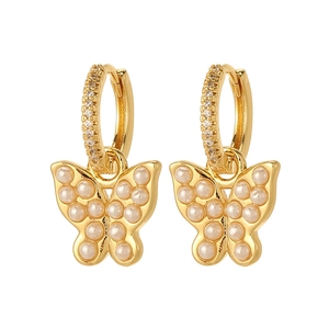 Gold butterfly drop earrings with white faux pearls and cubic zirconia on white background