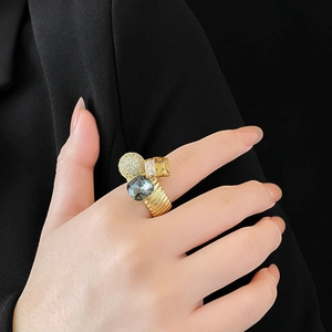 Detailed view of gold plated spiral ring featuring cubic zirconia and colored crystals
