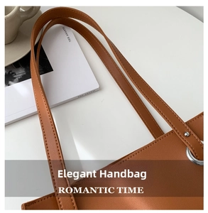 Close-up of brown leather tote bag with silver metal ring and fine stitching detail