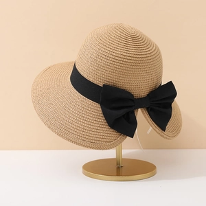 Chapeau de soleil élégant en paille beige avec grand nœud noir sur support doré