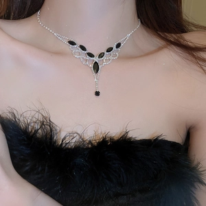 Close-up of model wearing black gemstone fringe necklace with silver chain and rhinestones