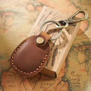 Vintage brown leather AirTag keychain holder with bronze hardware and hand-stitched detail