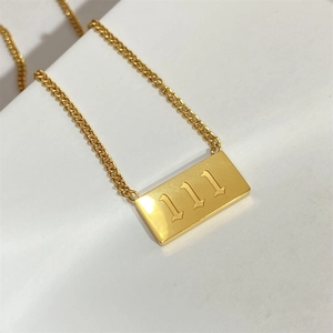 Detail view of gold 111 angel number necklace with cuban chain and rectangular tag