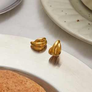 Close-up of golden twisted hoop earrings with polished metal finish and elegant design