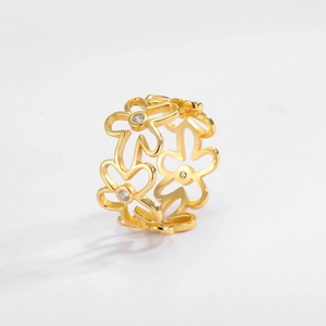 Macro shot of gold hollow flower ring featuring delicate zircon stone center detail