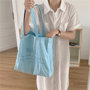 Hellblaue Canvas-Tragetasche mit Bébé-Stickerei und motivierendem Zitat für den Alltag