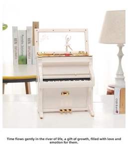 Macro detail of white piano music box showing keys, golden pedals and ballerina