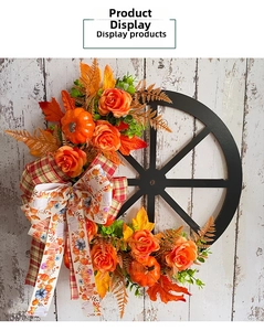 Close-up of rustic autumn wreath with pumpkins and roses on a black wooden wheel