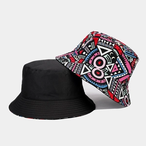 Detail of reversible bucket hat showing plain black side and colorful geometric print pattern
