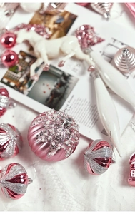 Detailed flat lay of diverse pink Christmas ornaments including glittery and beaded balls