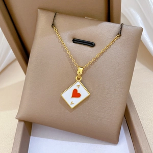 Detailed shot of gold titanium necklace with ace of hearts pendant and sparkling crystals