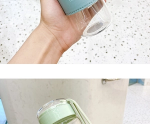 Detail of clear glass water bottle with light blue leather sleeve and green lid strap