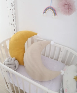 Quilted cotton moon pillows for nursing, shown in yellow and beige colors in a crib