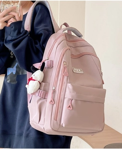 Pink durable nylon school backpack with side buckles and cute cartoon charm detail