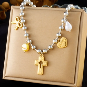 Detail der silbernen Perlenkette mit Kreuz, Herzanhänger und Perle im Lagenlook