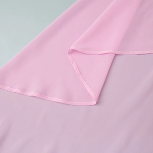 Detail van lichtroze chiffon stof met golvende randafwerking voor dameskleding