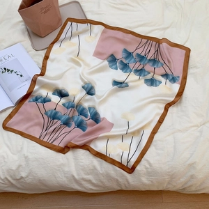 Detail of elegant silk square scarf with blue and yellow ginkgo leaf print design