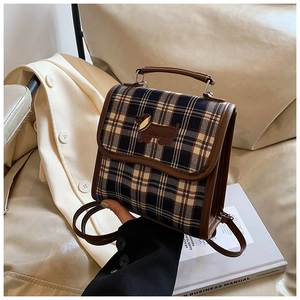 Close-up of a vintage plaid backpack featuring a cute dachshund embroidery and top handle