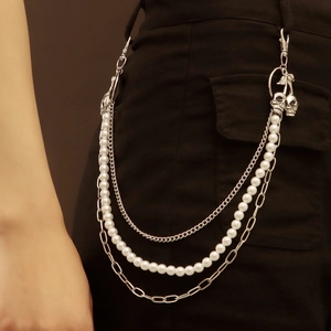 Detail of silver multi-layer waist chain with skull charms and white pearls for jeans