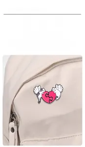 Detailed view of cat heart enamel pin attached to a canvas bag for decoration