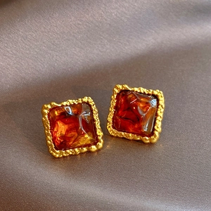 Vintage irregular square resin earrings with gold textured edges on dark silk background