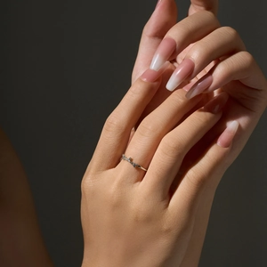 Macro close-up of s925 silver ring with zircon stones on female finger with gradient nails