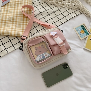 Close-up of canvas crossbody bag featuring pink pockets and clear PVC card slot
