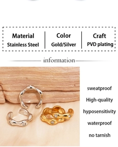 Detailed view of gold and silver PVD plated stainless steel ear cuffs on soft fabric