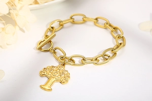 Detailed view of golden chain bracelet featuring a heart-shaped tree of life pendant