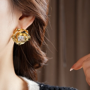 Détail de boucles d'oreilles roses plaquées or 18k avec zircon cubique carré au naturel