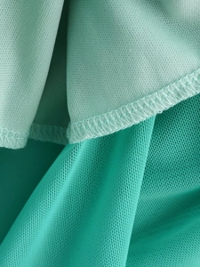Makrodetail aus minzgrünem Netzstoff mit professioneller Overlock-Naht an der Kante