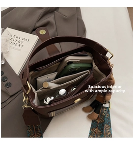 Interior view of brown bucket bag showing large capacity with zipper compartments