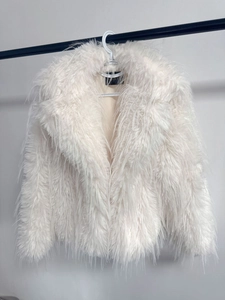 Detail of white faux fur jacket showing high-quality long plush fibers and soft texture
