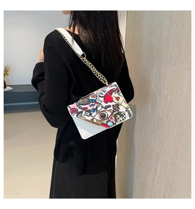 Detail of white graffiti crossbody bag with colorful prints and gold chain strap