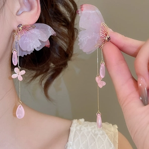 Detail of elegant gold butterfly earrings with long pink flower tassels and pearl drops