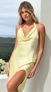 Détail du design dos nu licou sur une robe longue en satin jaune clair soyeux