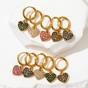 Golden stainless steel hoop earrings with colorful zircon heart pendants on white stone
