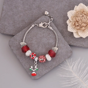 Detail of silver snake chain bracelet with red crystal beads and reindeer charm