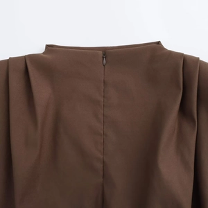 Macro shot of invisible back zipper and pleated shoulder detail on sleeveless top