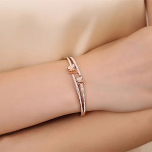 Macro view of rose gold and silver double butterfly bracelet with sparkling zircon stones